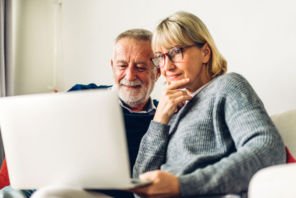 Senior couple family having good time using laptop computer toge